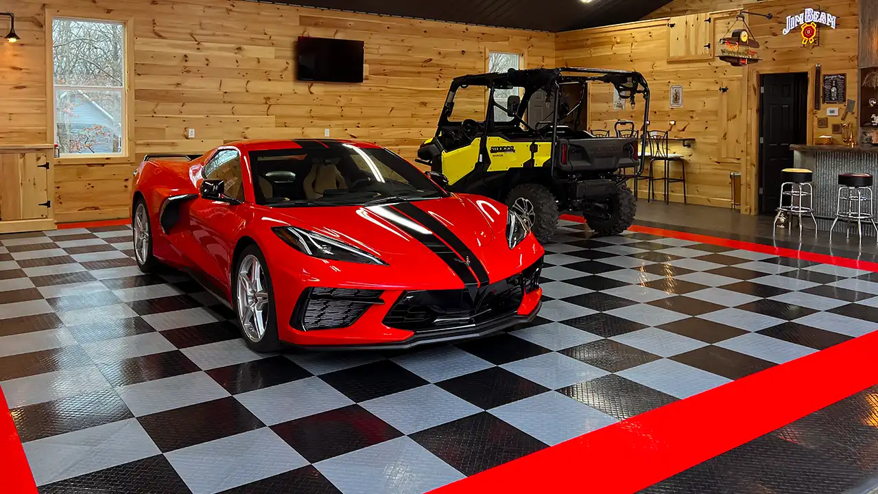 Corvette and ATV in a garage with RaceDeck Diamond. The floor has a checkerboard pattern with a red border. There's wood paneling on the wall.